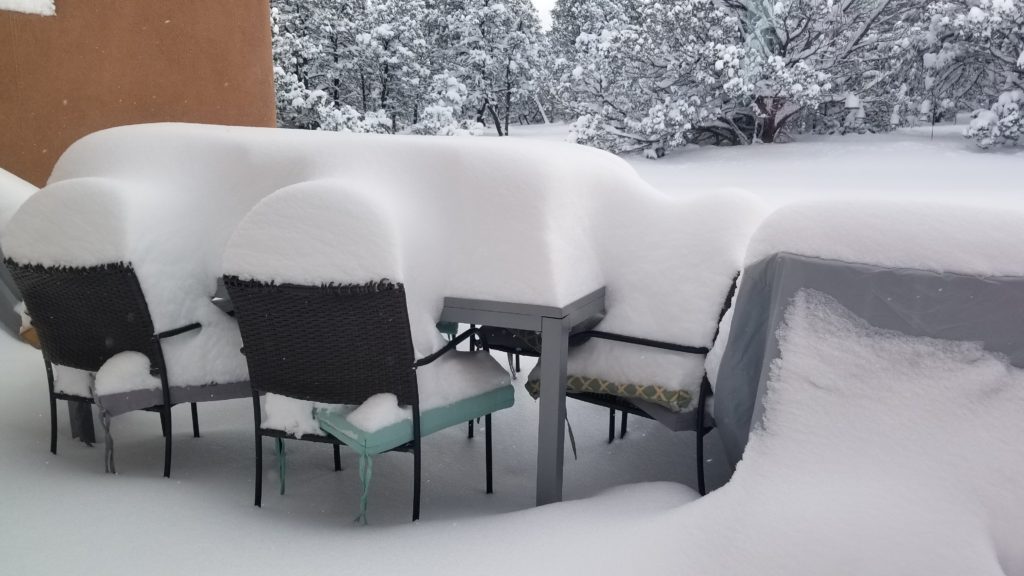 Two feet of snow covered patio furniture.