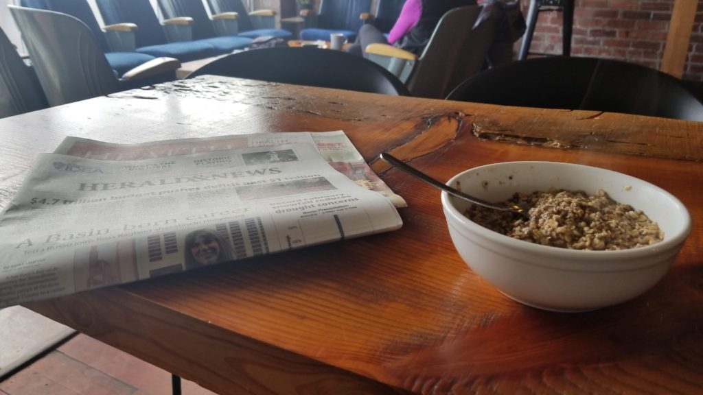 Bowl of oatmeal and a newspaper.