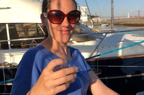 Lis toasting the camera from a sailboat